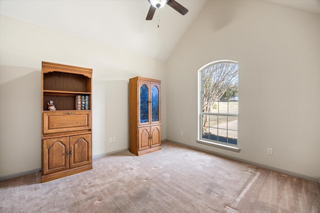 interior space featuring ceiling fan, light colored carpet, and high vaulted ceiling