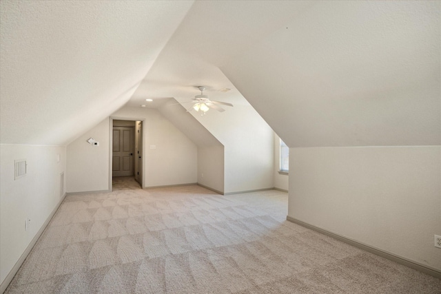 bonus room featuring ceiling fan, lofted ceiling, light carpet, and a textured ceiling