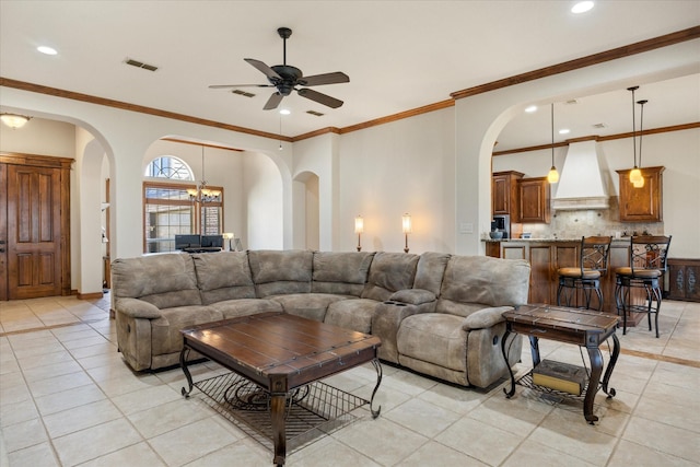 living room featuring ceiling fan with notable chandelier, ornamental molding, and light tile patterned flooring