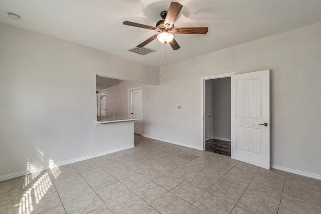 tiled spare room featuring ceiling fan