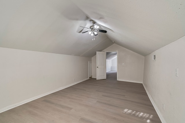 bonus room with hardwood / wood-style floors, vaulted ceiling, a textured ceiling, and ceiling fan