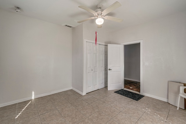 unfurnished bedroom featuring ceiling fan, a closet, and light tile patterned floors