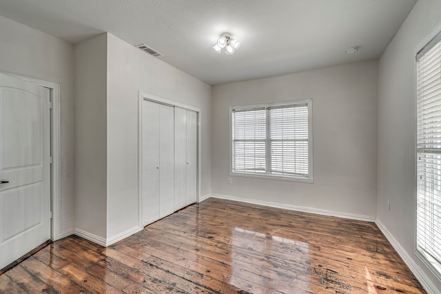 unfurnished bedroom featuring dark hardwood / wood-style flooring and a closet