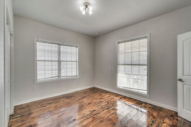 unfurnished room with dark hardwood / wood-style flooring