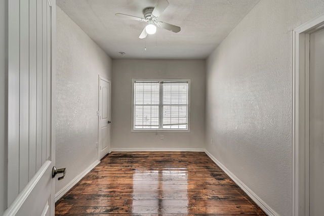 empty room with dark wood-type flooring, ceiling fan, and a textured ceiling