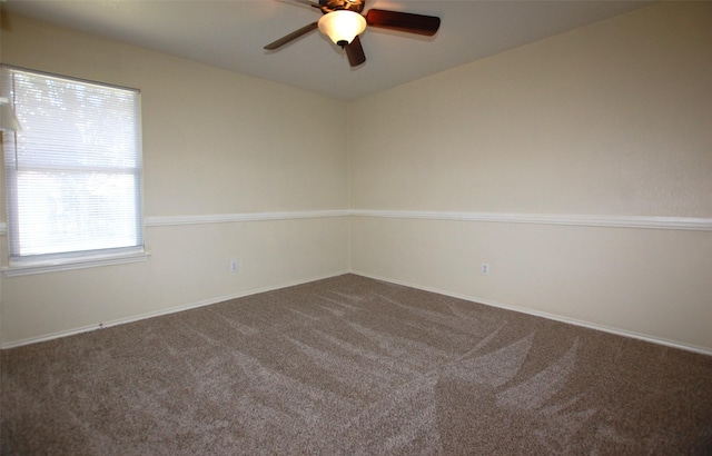 empty room featuring ceiling fan and carpet