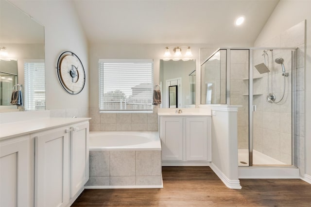 bathroom featuring hardwood / wood-style flooring, shower with separate bathtub, lofted ceiling, and vanity