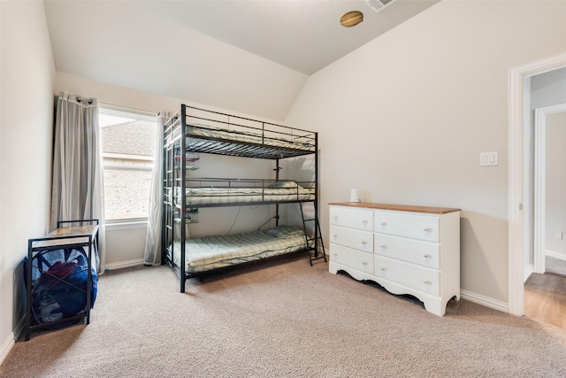 carpeted bedroom with lofted ceiling