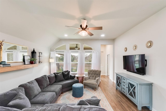 living room featuring ceiling fan, lofted ceiling, and light hardwood / wood-style flooring