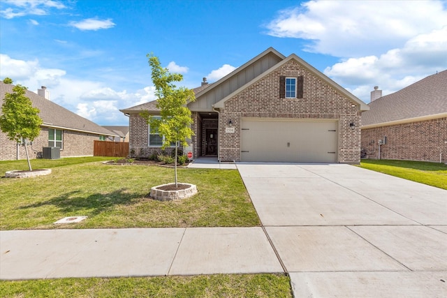 view of front of property with a fire pit, a garage, central AC, and a front lawn