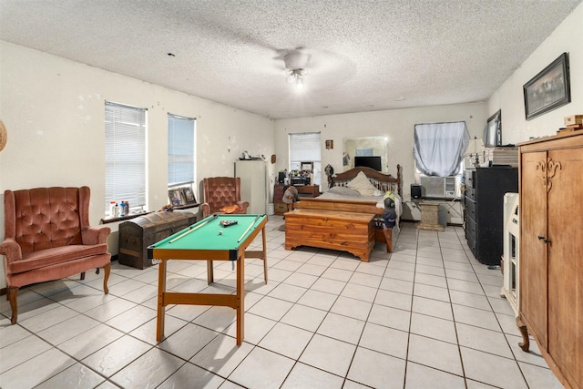 tiled bedroom with multiple windows, a textured ceiling, and billiards