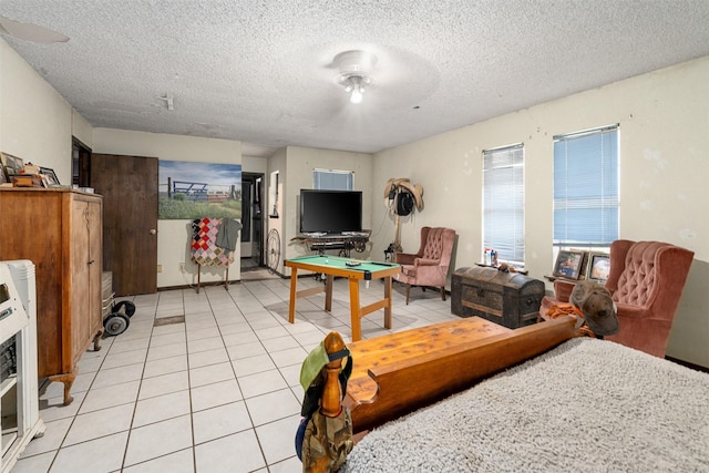 tiled living room with heating unit and a textured ceiling