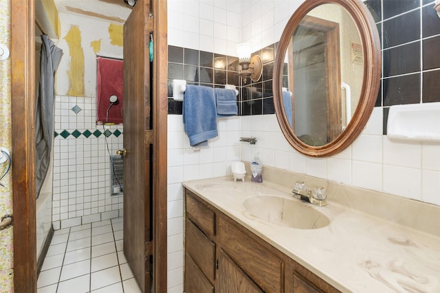 bathroom with tile walls, vanity, and tile patterned flooring