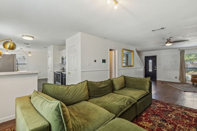 living room with ceiling fan and dark hardwood / wood-style flooring