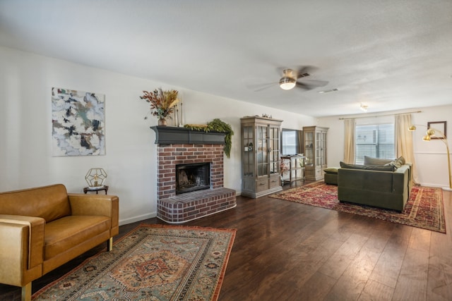 living room featuring dark hardwood / wood-style flooring, a fireplace, and ceiling fan