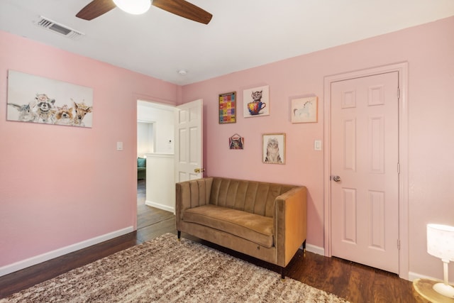 living area with ceiling fan and dark hardwood / wood-style floors