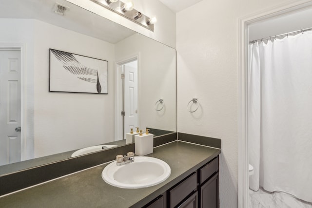 bathroom featuring vanity and toilet