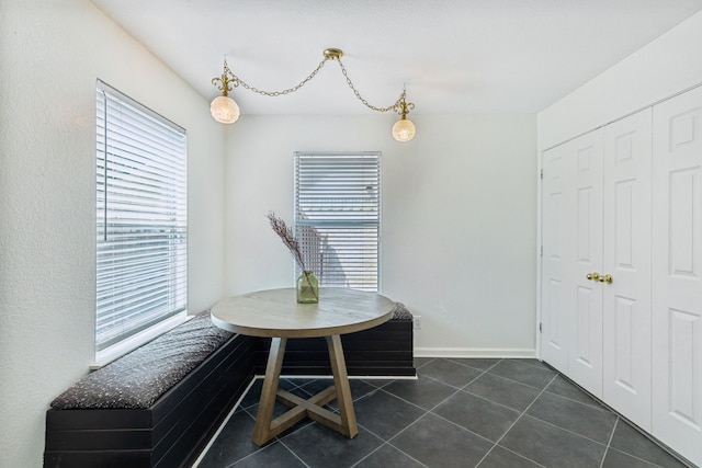 unfurnished dining area with dark tile patterned flooring