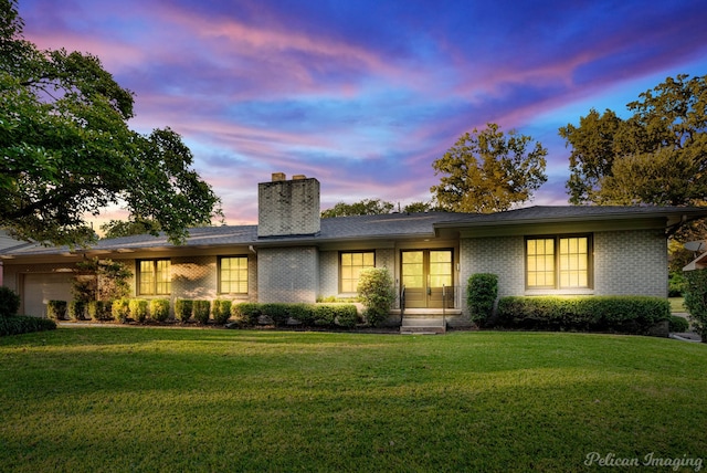 view of front of house featuring a garage and a lawn