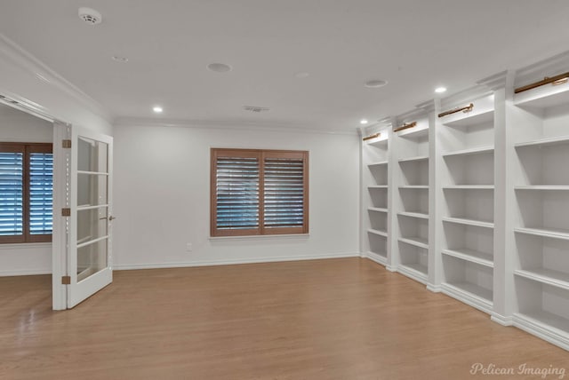 unfurnished room featuring crown molding, built in features, and light wood-type flooring