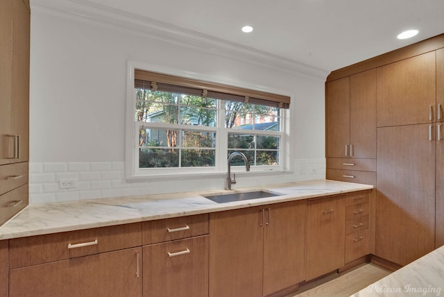 kitchen featuring a healthy amount of sunlight, ornamental molding, sink, and decorative backsplash