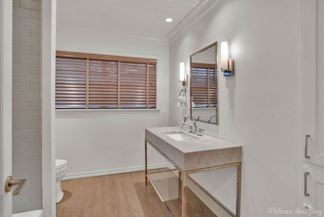 bathroom with crown molding, sink, hardwood / wood-style floors, and toilet