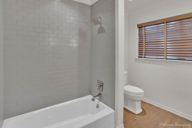 bathroom with tiled shower / bath, wood-type flooring, and toilet