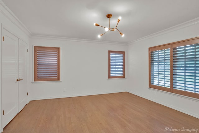 unfurnished room featuring crown molding, light wood-type flooring, and an inviting chandelier