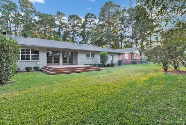 rear view of house featuring a wooden deck, a yard, and cooling unit