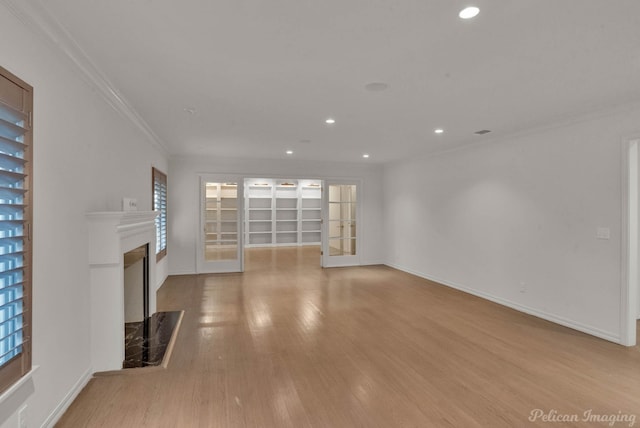 unfurnished living room with ornamental molding, a fireplace, and light hardwood / wood-style floors