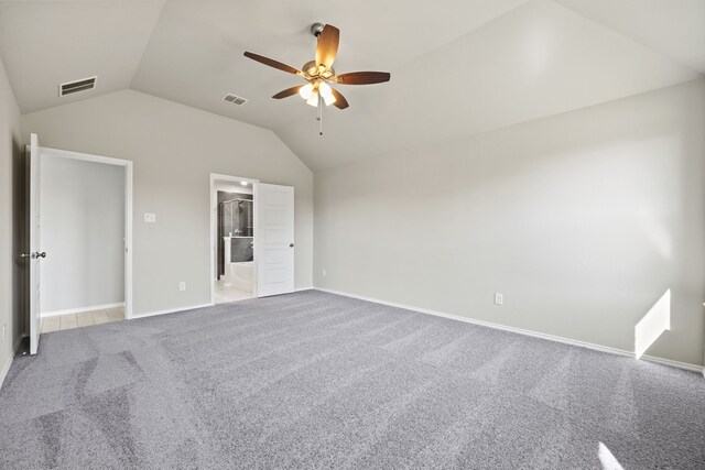 unfurnished bedroom featuring vaulted ceiling, carpet flooring, ensuite bathroom, and ceiling fan