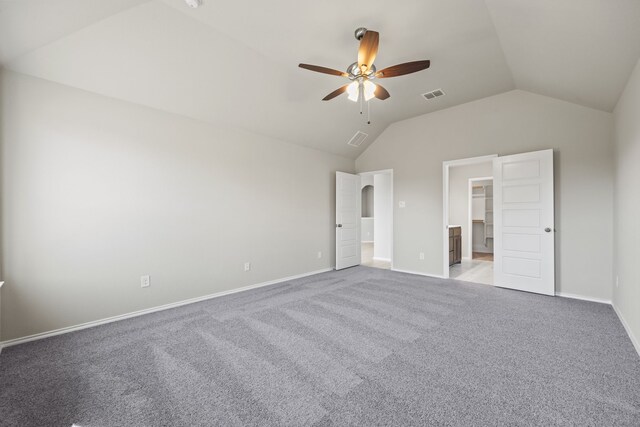 unfurnished bedroom featuring lofted ceiling, a spacious closet, light colored carpet, and ceiling fan