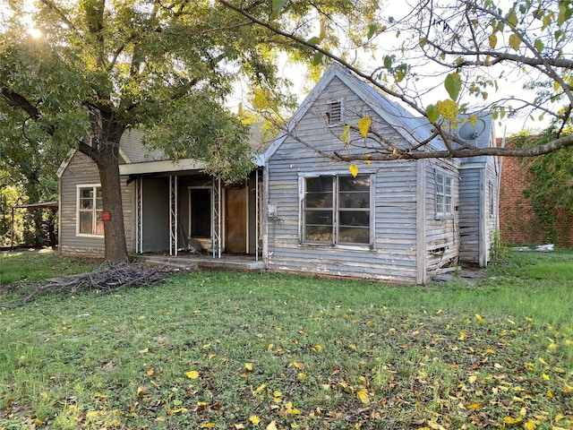 rear view of house featuring a lawn