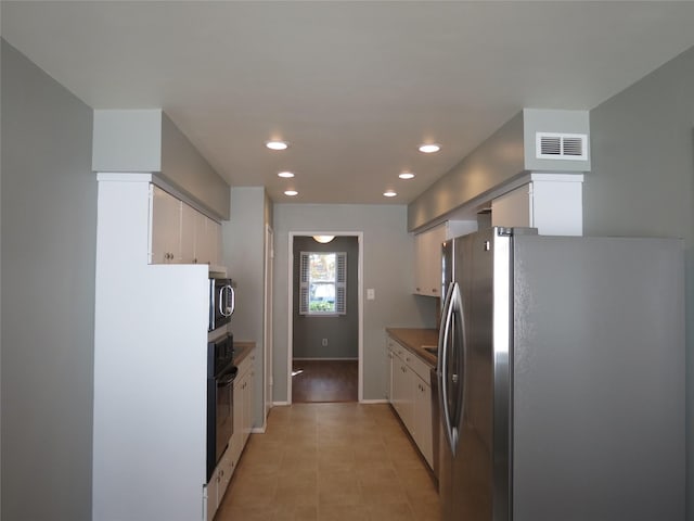 kitchen featuring stainless steel appliances and white cabinets