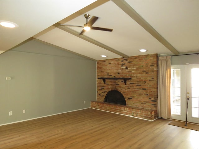 unfurnished living room featuring ceiling fan, vaulted ceiling with beams, a fireplace, wood-type flooring, and french doors