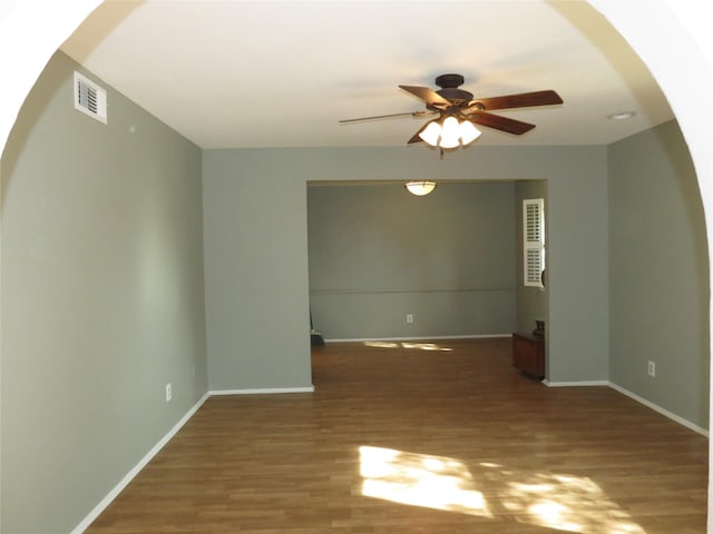 spare room with dark hardwood / wood-style flooring and ceiling fan