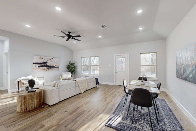 dining area with ceiling fan, vaulted ceiling, and light hardwood / wood-style flooring