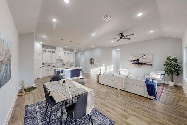 dining room featuring sink, vaulted ceiling, light hardwood / wood-style floors, and ceiling fan