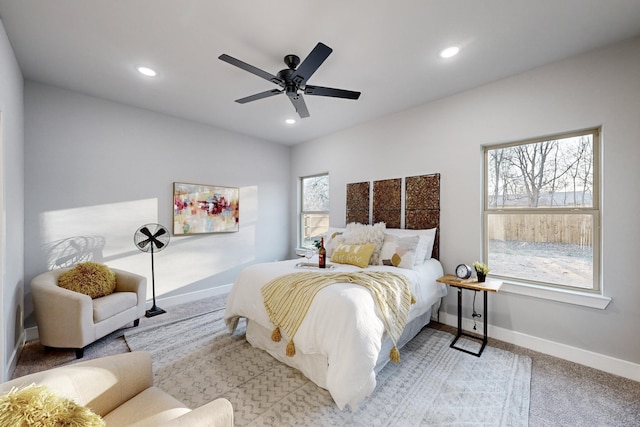 carpeted bedroom featuring multiple windows and ceiling fan