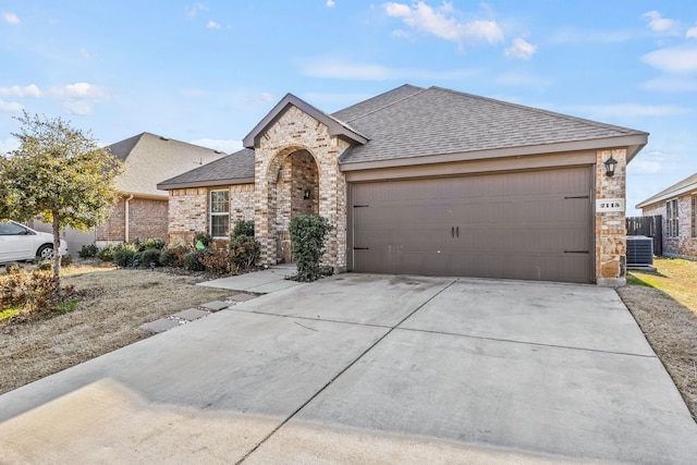 ranch-style house with a garage and central AC unit