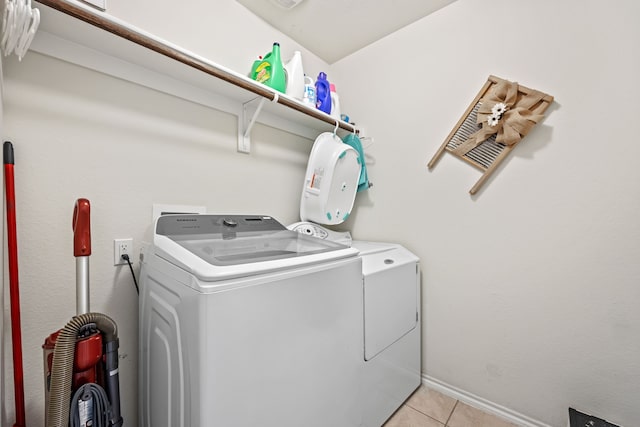 laundry area featuring washer and clothes dryer and light tile patterned floors