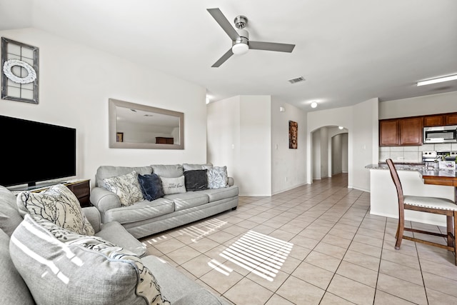 tiled living room with vaulted ceiling and ceiling fan