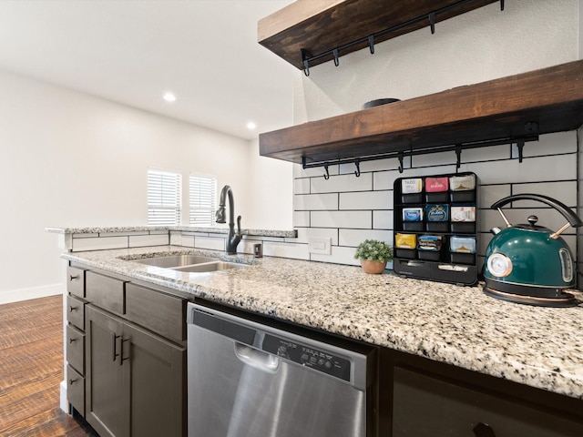 kitchen featuring light stone counters, a sink, stainless steel dishwasher, and open shelves