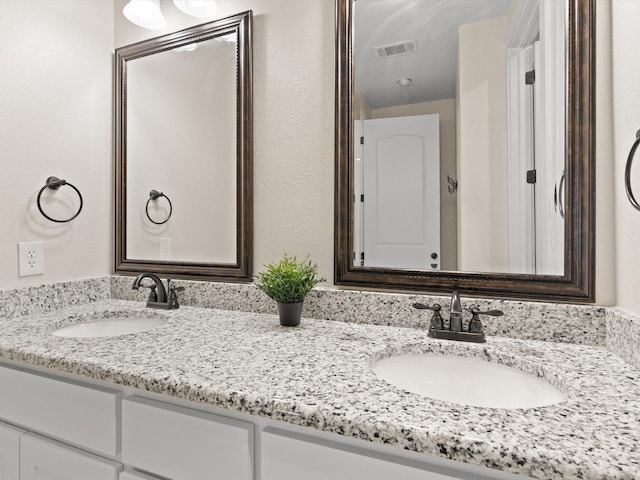 full bath with visible vents, a sink, and double vanity