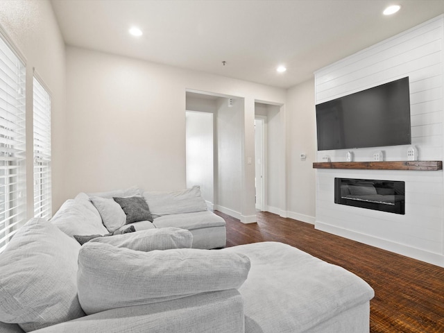 living room featuring dark wood-style floors, recessed lighting, a glass covered fireplace, and baseboards