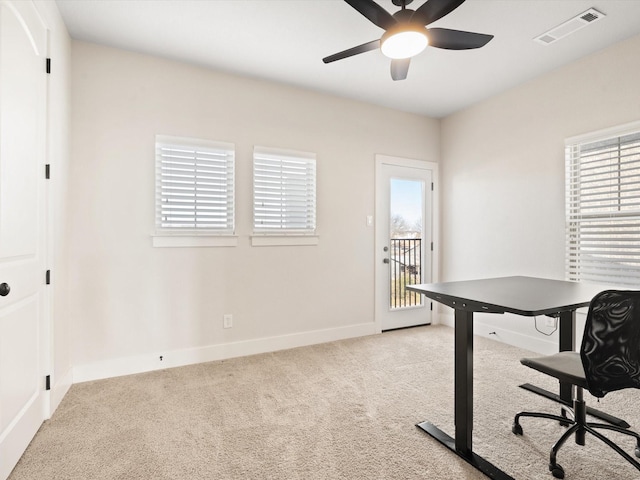 home office with light carpet, ceiling fan, a wealth of natural light, and visible vents