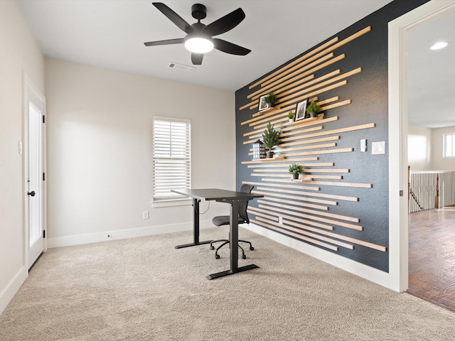 office area with light carpet, baseboards, visible vents, and ceiling fan