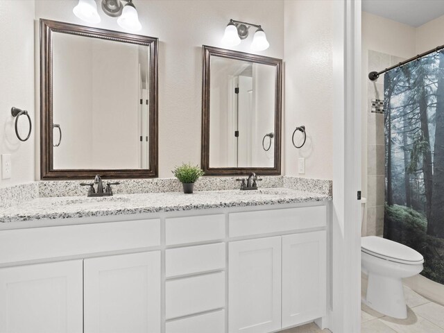 bathroom with toilet, a sink, a shower with curtain, tile patterned floors, and double vanity