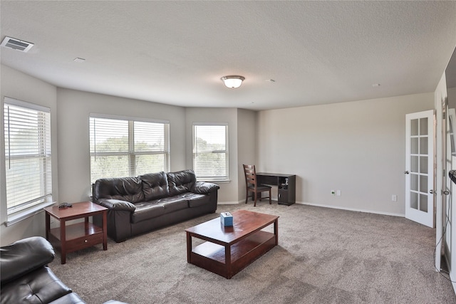 living room with light carpet, a textured ceiling, and french doors