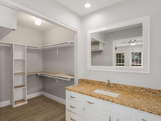 spacious closet with sink, dark hardwood / wood-style floors, and ceiling fan